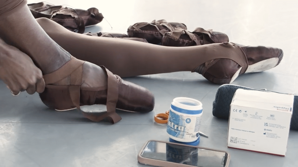 Precious Adams prepares her pointe shoes