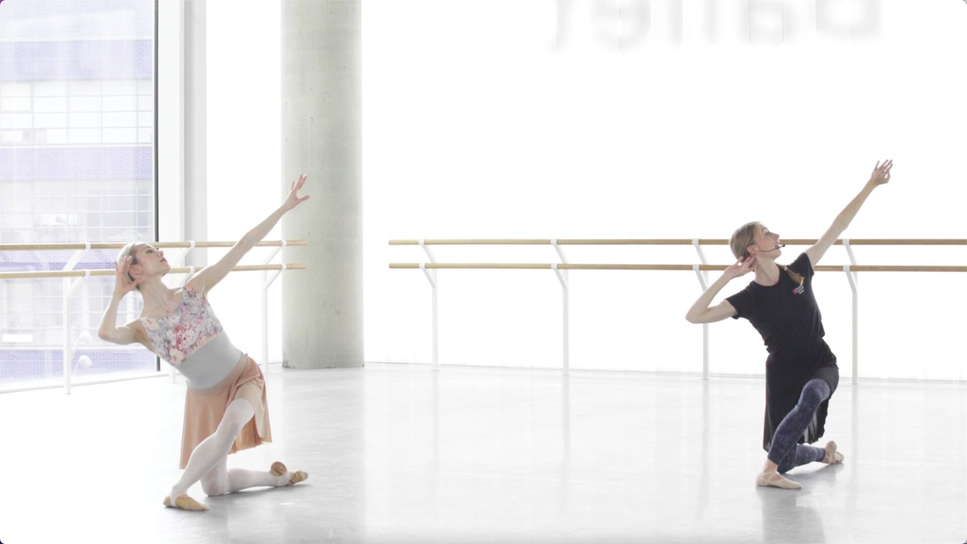 One ballet teacher and a demonstrator are performing in a bright